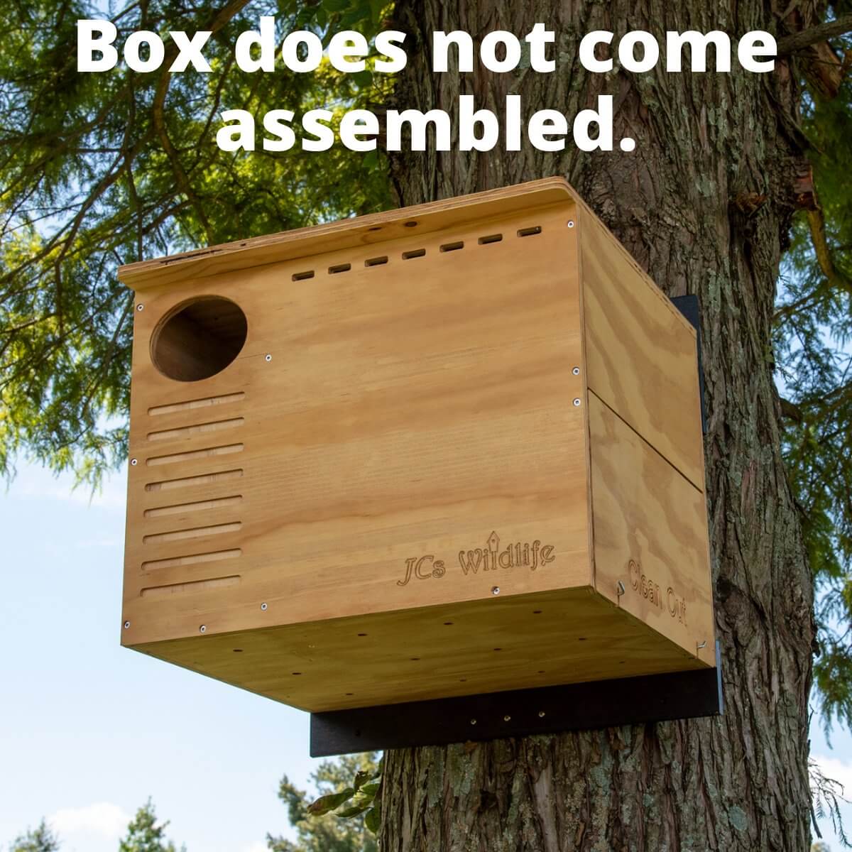 JCS Wildlife Barn Owl Nesting Box displayed on a tree, unassembled, showcasing DIY assembly option.