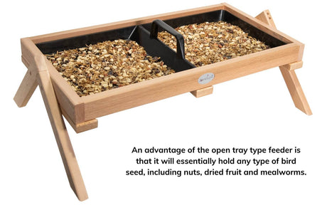 JCS Wildlife Cedar Platform Ground Feeder XL with bird seed, designed to attract various birds to your yard.