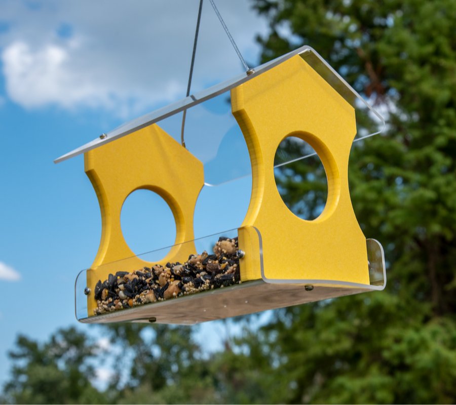 JCS Wildlife Recycled Poly Lumber Hanging Bird Feeder with bird seed, attracting Cardinals, Bluebirds, and more. Vibrant yellow color.