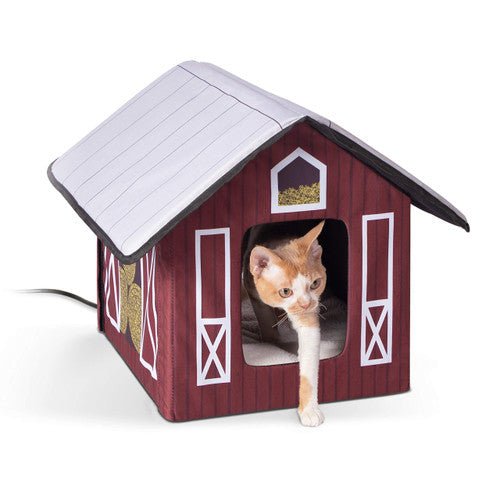 Cat in a K&H Outdoor Heated Kitty House Barn on a white background, featuring a barn-style design for use in barns, garages, and porches.