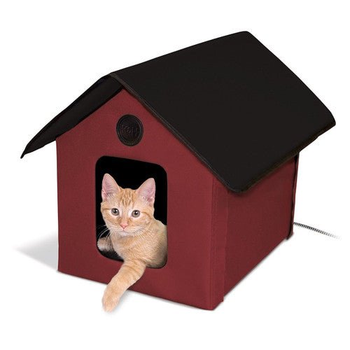 Orange cat inside K&H Pet Products Outdoor Thermo Kitty House in red and black, heated for extra warmth and comfort.