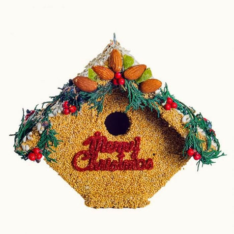 "Christmas-themed wooden Wren house covered with bird seed, almonds, juniper, and decorated with a Merry Christmas sign"