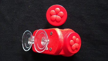 Nectar DOTS window hummingbird feeder with two suction cups, two red nectar containers with red flowers, and a sleek design.