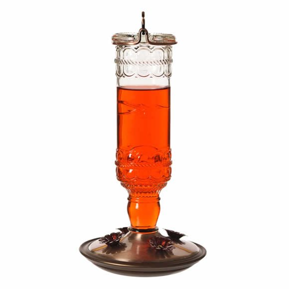 Perky-Pet Antique Bottle Glass Hummingbird Feeder with 4 feeding ports and 10 oz capacity hanging with nectar