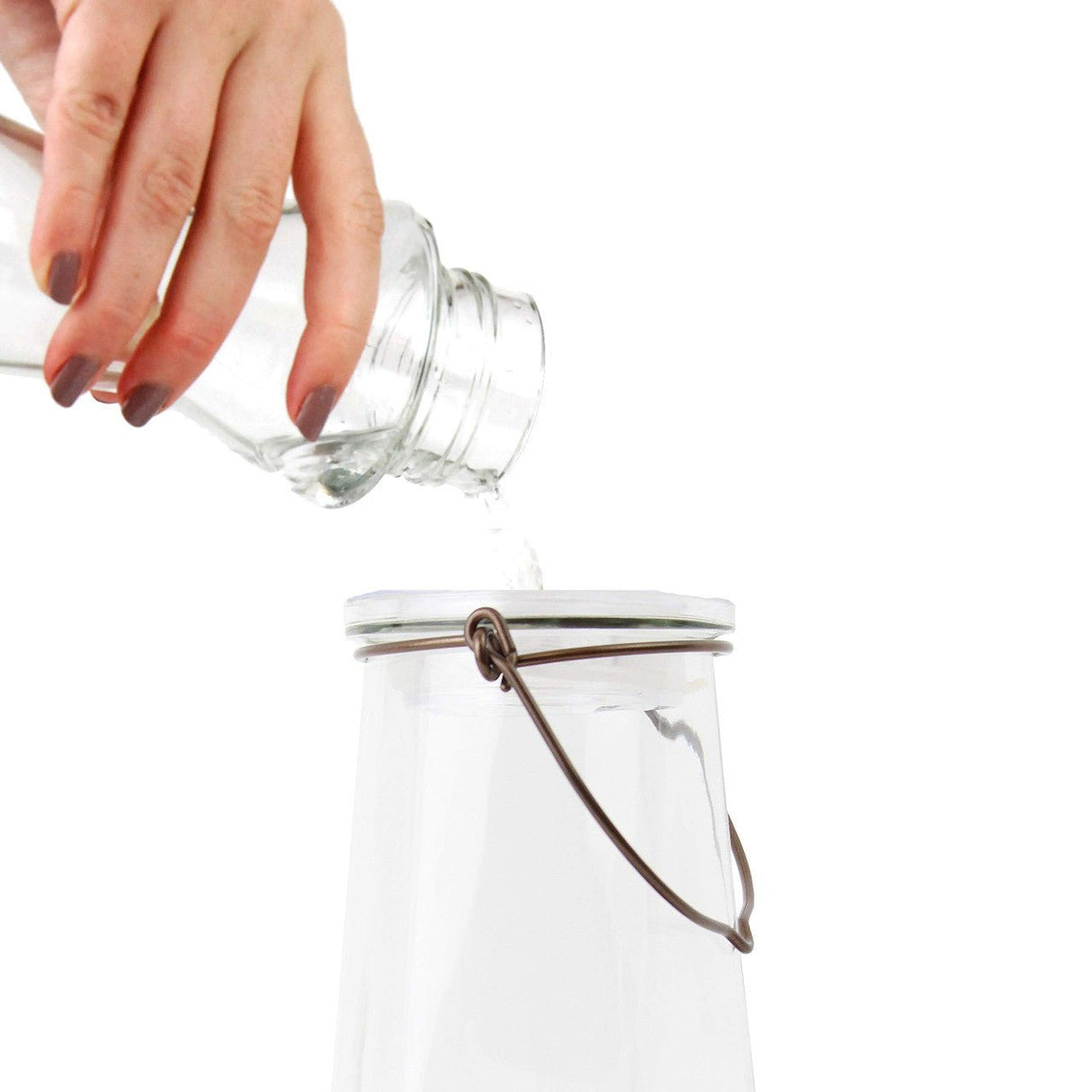 Pouring nectar into Perky-Pet 9109 Crystal Top-Fill Glass Hummingbird Feeder with wide-mouth opening for easy and mess-free filling.