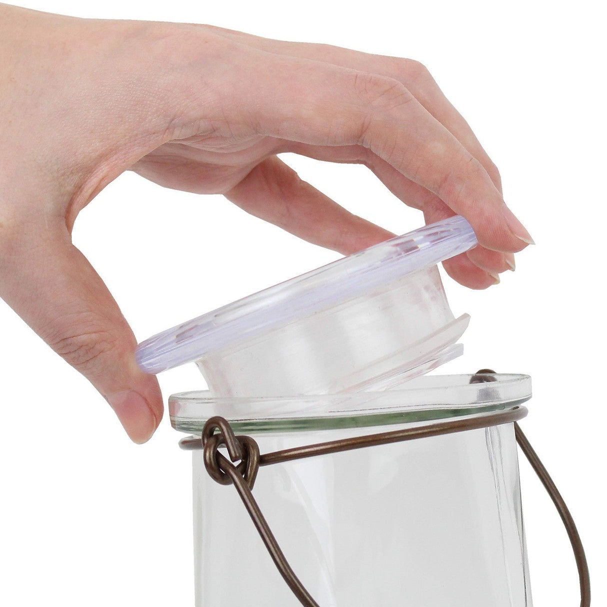 Hand removing lid of Perky-Pet Crystal Top-Fill Glass Hummingbird Feeder for easy filling