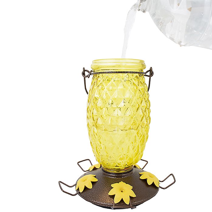 Filling Perky-Pet Pineapple Top-Fill Glass Hummingbird Feeder with nectar - 28 oz capacity, wide-mouth opening, and mess-free top-fill design