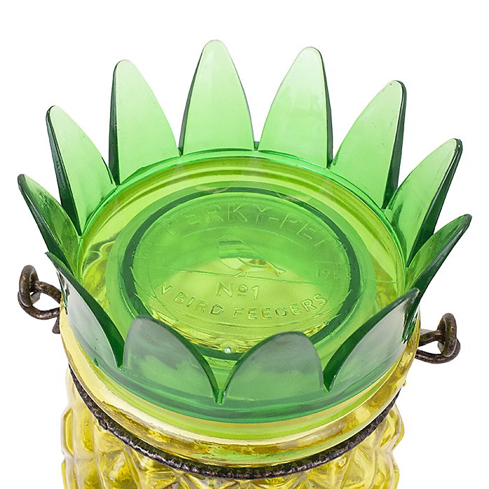 Perky-Pet Pineapple Top-Fill Glass Hummingbird Feeder top view with green leaves and yellow base
