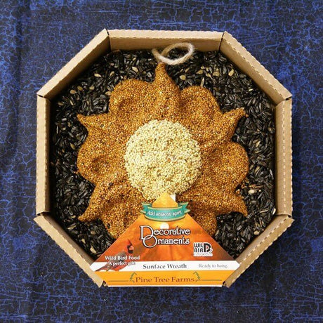 Pine Tree Farms Sun Face Seed Wreath in packaging with black oil sunflower, white millet, and red millet seeds for bird feeding