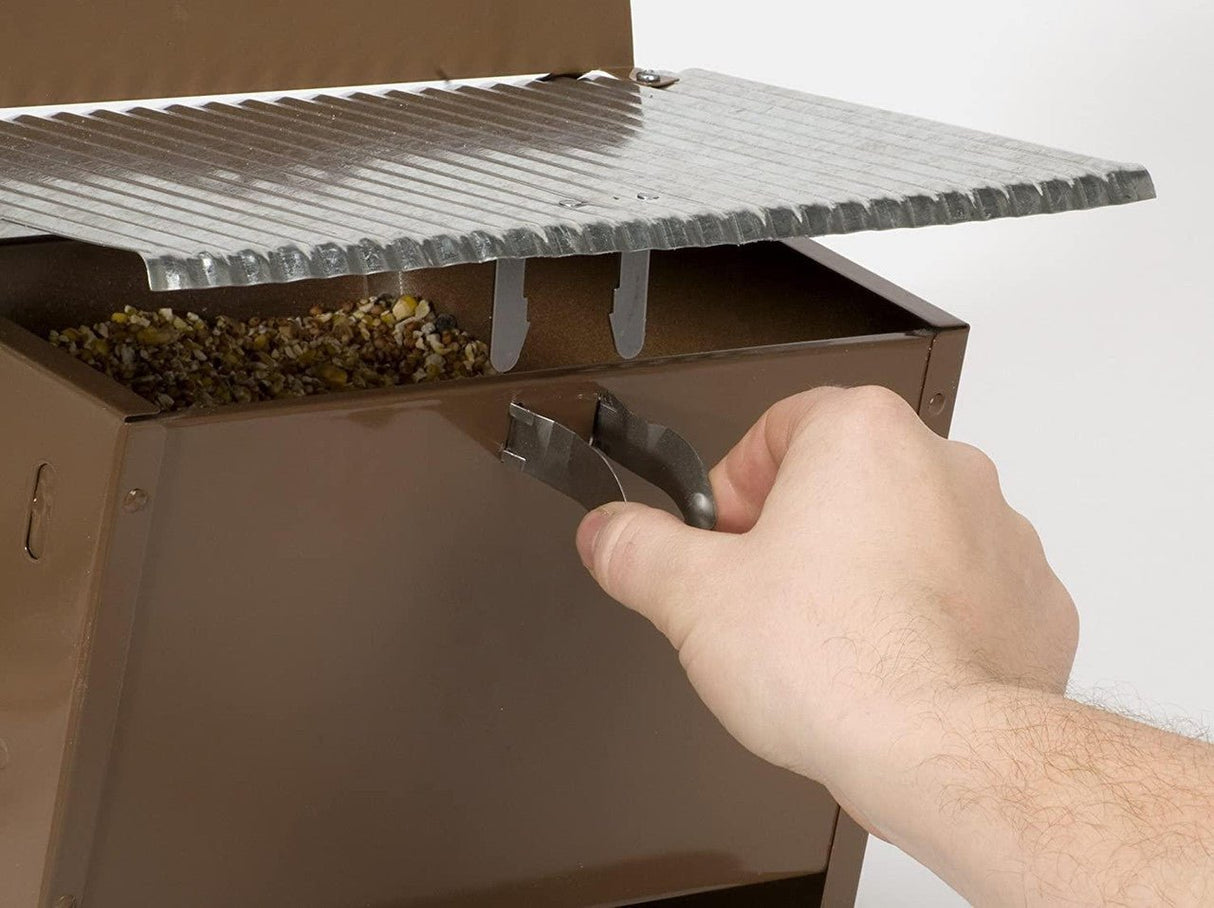 Hand securing locking top of Woodlink Rustic Farmhouse Absolute® Feed & Seed Squirrel-Resistant Feeder 24637.