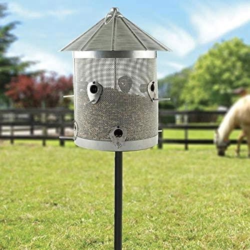 Woodlink Rustic Farmhouse Galvanized Silo Combo Seed Feeder in a garden, designed for small birds and holding 10lbs of seeds.