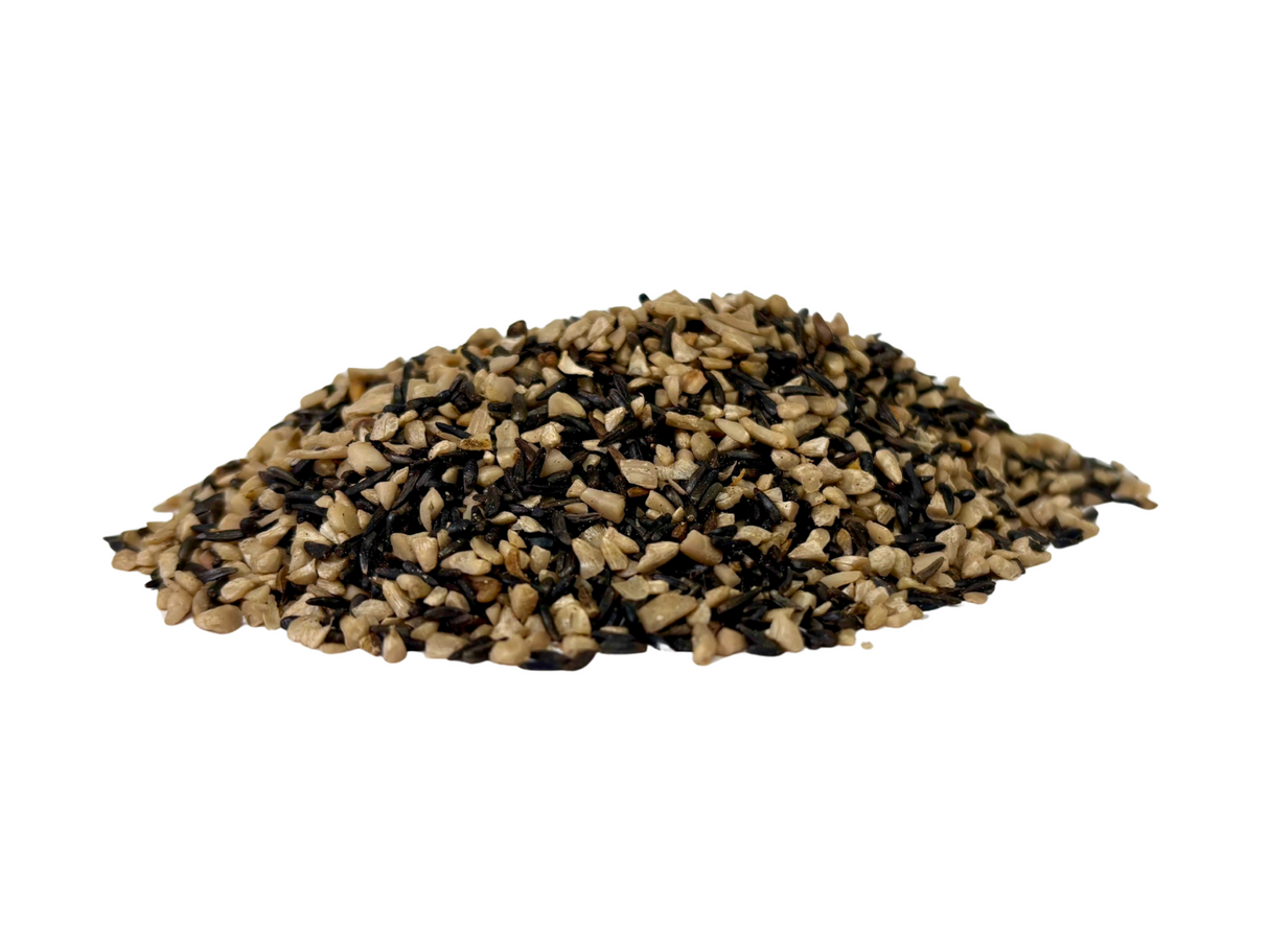 Photograph of a pile of mixed birdseed showing tan and dark brown sunflower seeds and niger seeds against a white background
