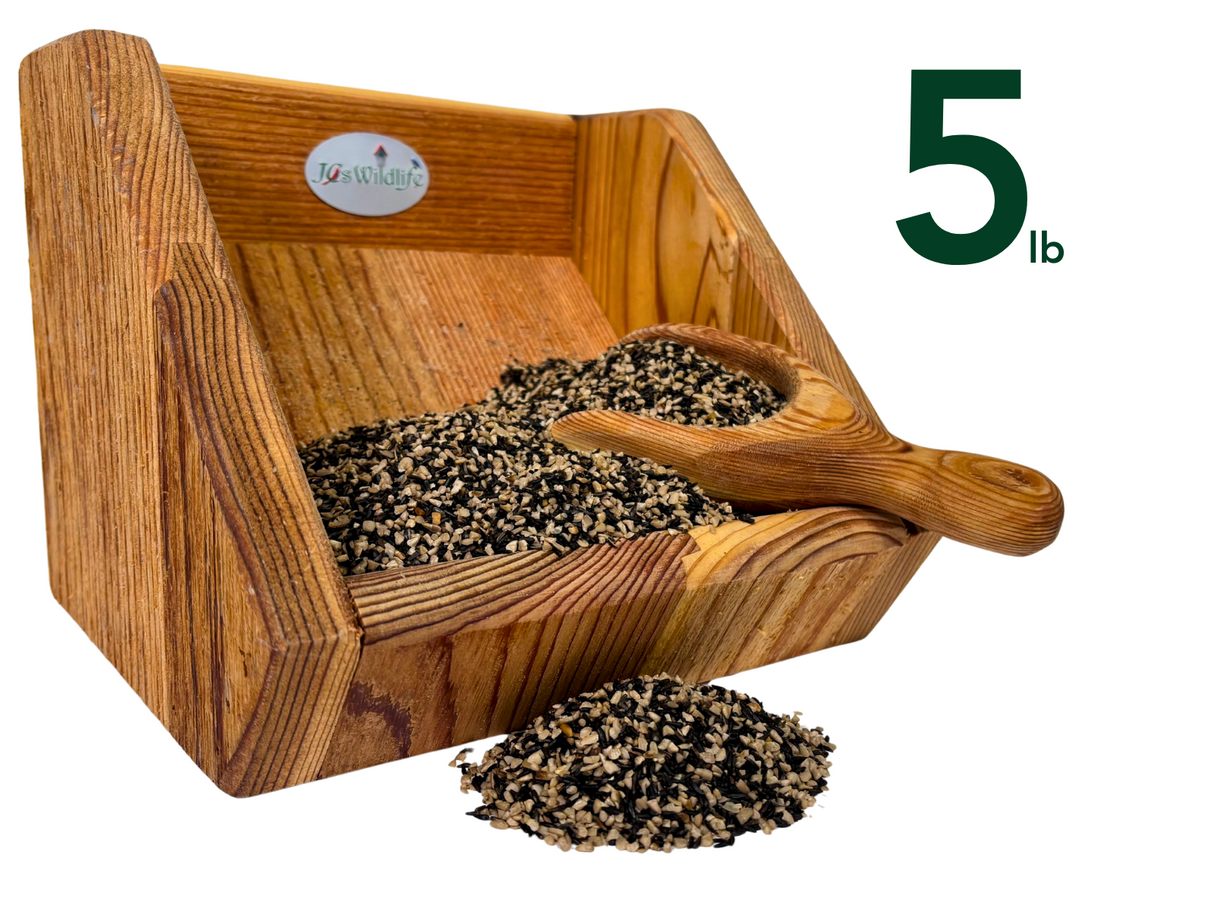 JGsWildlife product photography shows a five pound wooden bird feeder filled with a mix of black and white seeds and a small wooden scoop showcasing the rich wood grain and the varied seed colors
