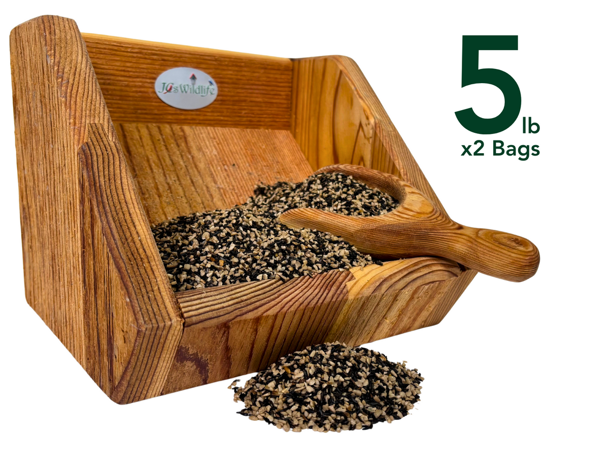 JGs Wildlife wooden bird feeder filled with black oil sunflower seeds and a small wooden scoop showing a mix of beige and black seeds with visible wood grain
