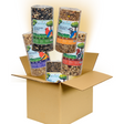 Jo's Wildlife product photography showing a cardboard box overflowing with premium birdseed blends including Wild Bird Blend, Bugs Nuts & Berries, and Finch Favorite featuring colorful bird illustrations and detailed ingredient labels
