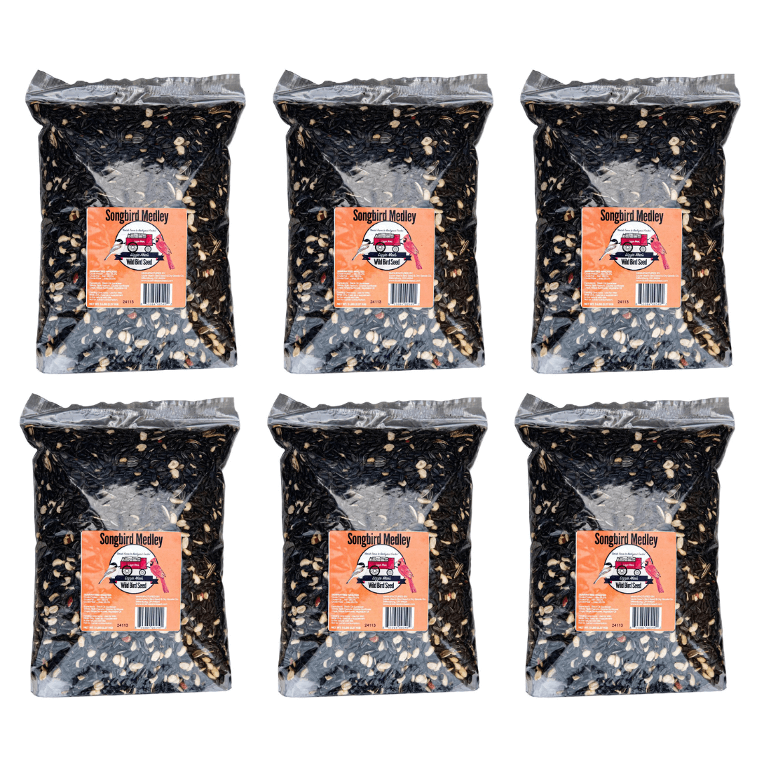 Six bags of JCS Wildlife Songbird Medley 5lb loose seed, featuring premium black oil sunflower seeds, split peanuts, and sunflower chips.