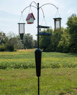 Squirrel Stopper Sequoia Squirrel Proof Bird Feeder Pole System with 4 hanging stations in a grassy yard.